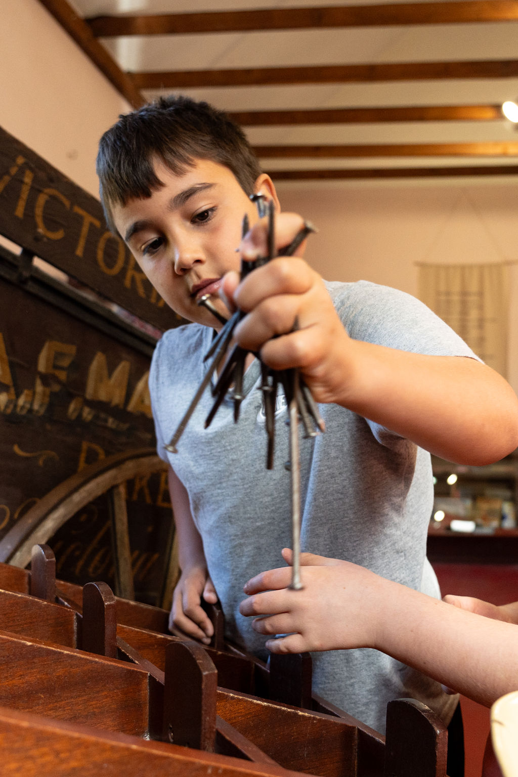 Boy holding a bunch of metal nails.