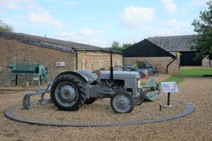 A small grey tractor with large wheels at the back and smaller ones at the front