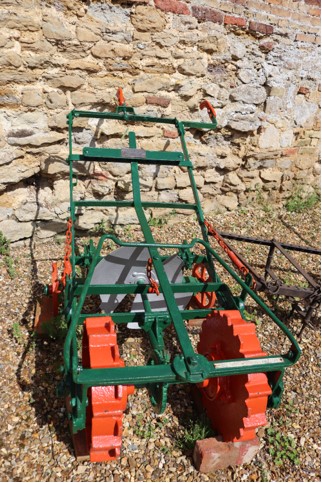 Red and green coloured historic farm machinery