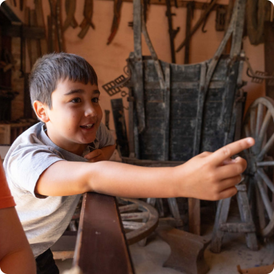 Boy pointing at museum wheelwright display