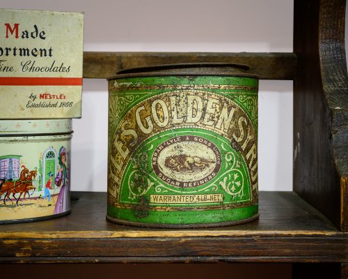 A slightly rusted green tin. The label states 'Lyle's Golden Syrup'.