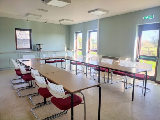 Tables and chairs set in a U-shape for a business meeting