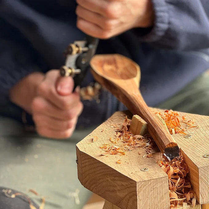 Man carving a wooden spoon.