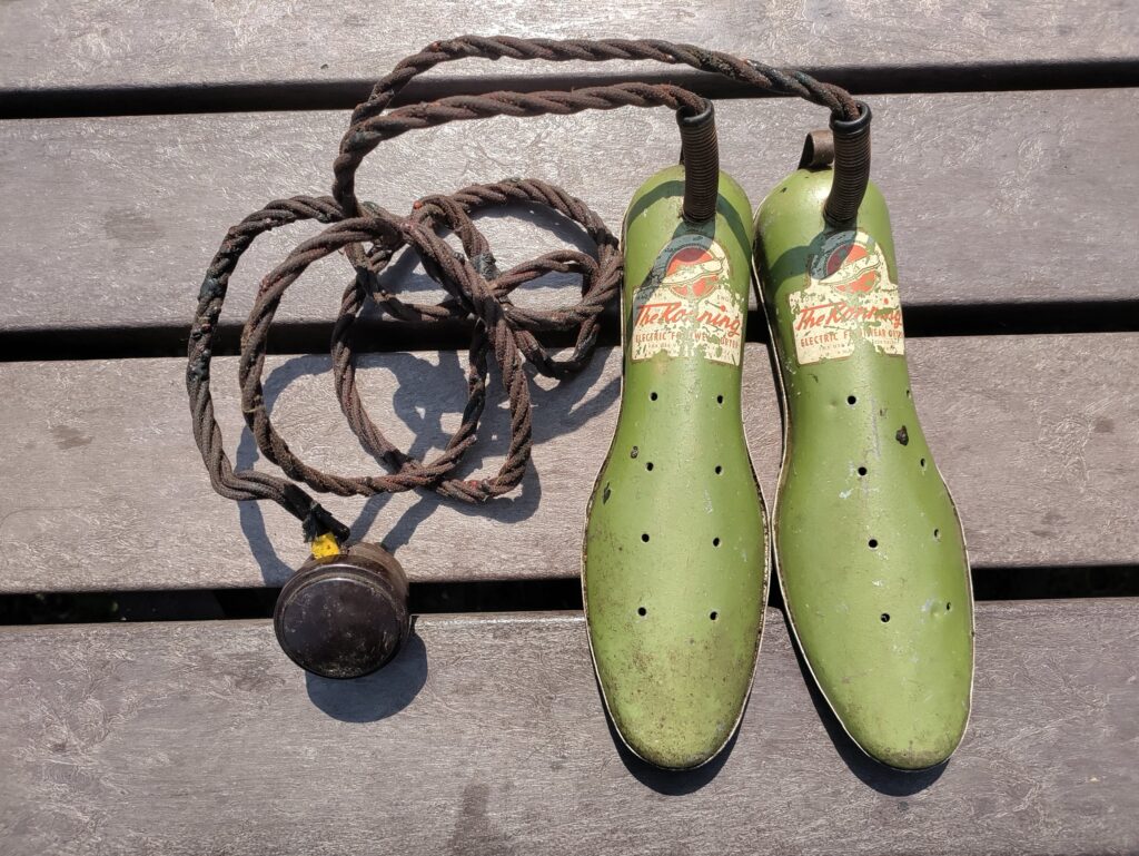 Two light green shoe shaped insoles connected to a single wire.